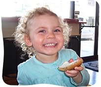 Little girl eating a bagel